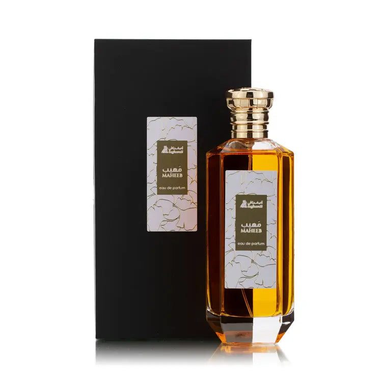 Perfume bottle with gold cap and black box on a white background