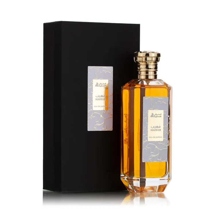 Perfume bottle with gold cap and black box on a white background